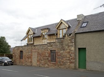 General view from SE showing new house within walls of earlier cottage.