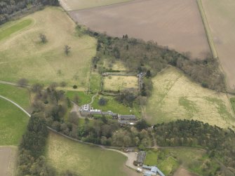 Oblique aerial view centred on the country house with the stable block and walled garden adjacent, taken from the N.