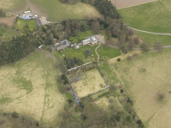 Oblique aerial view centred on the country house with the stable block and walled garden adjacent, taken from the S.