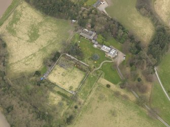 Oblique aerial view centred on the country house with the stable block and walled garden adjacent, taken from the SE.