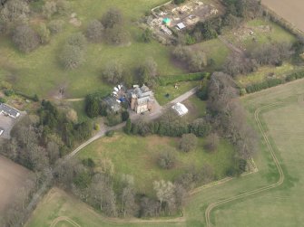 Oblique aerial view centred on the country house with the walled garden and stables adjacent, taken from the SW.