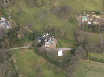 Oblique aerial view centred on the country house with the walled garden and stables adjacent, taken from the SSW.