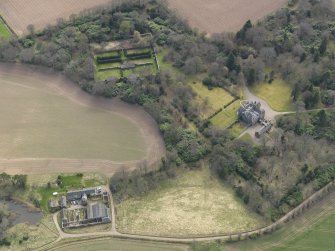 Oblique aerial view centred on the country house with the walled garden adjacent, taken from the NNW.