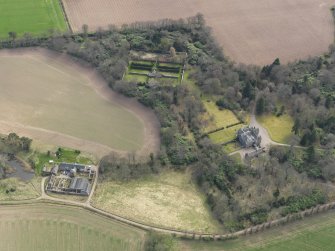 Oblique aerial view centred on the country house with the walled garden adjacent, taken from the N.