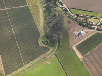 Oblique aerial view centred on the remains of the church with the burial ground adjacent, taken from the NNW.