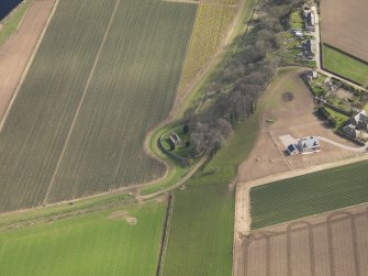 Oblique aerial view centred on the remains of the church with the burial ground adjacent, taken from the NW.
