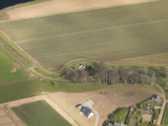 Oblique aerial view centred on the remains of the church with the burial ground adjacent, taken from the SW.