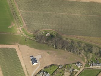 Oblique aerial view centred on the remains of the church with the burial ground adjacent, taken from the S.