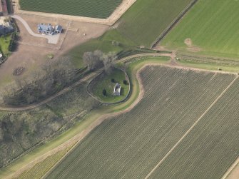 Oblique aerial view centred on the remains of the church with the burial ground adjacent, taken from the NE.