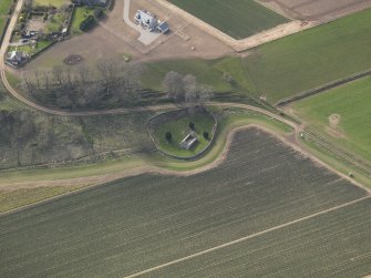 Oblique aerial view centred on the remains of the church with the burial ground adjacent, taken from the NNE.