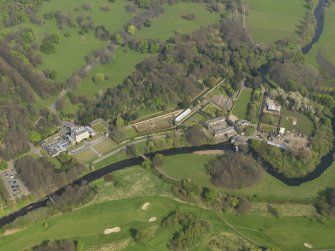 General oblique aerial view centred on the house with the stable block adjacent, taken from the SW.