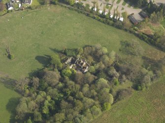 Oblique aerial view centred on the remains of the country house, taken from the NW.