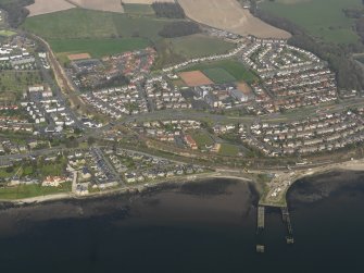 General oblique aerial view centred on the town with the pier adjacent, taken from the SW.