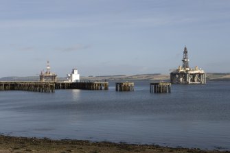 General view from NW of pier, control tower and oil rig.