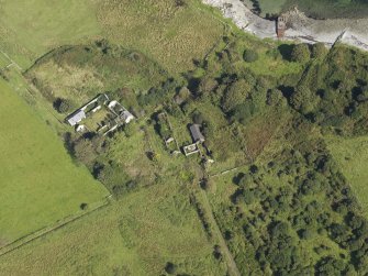 Oblique aerial view centred on the two farmsteads and site of the chapel (at the top left), taken from the SSW.
