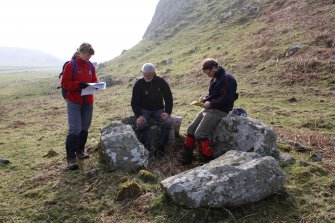 RCAHMS staff (Angela Gannon, Ian Parker and George Geddes) discuss the burial chamber at Dunagoil.