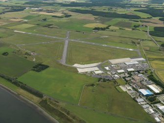 General oblique aerial view centred on the airfield with the technical site (terminal) adjacent, taken from the WNW.