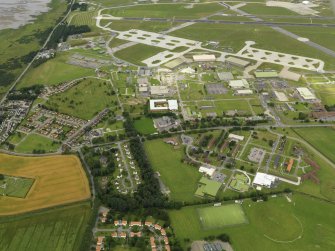 General oblique aerial view centred on the technical site with the airfield adjacent, taken from the SE.