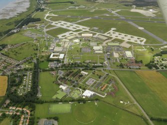 General oblique aerial view centred on the technical site with the airfield adjacent, taken from the SE.