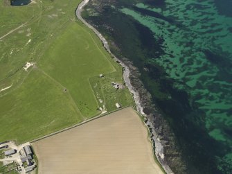 Oblique aerial view centred on the remains of the broch and the coastal battery, taken from the E.