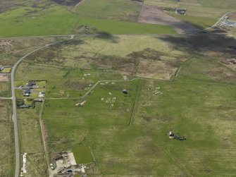 Oblique aerial view centred on the concrete nissen hut floors at Longtownmail, taken from the NE.