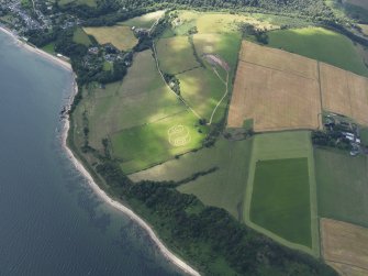 Oblique aerial view centred on a symbol cut in the grass, probably by artist Brian Wright with Kincurdie House with the town of Rosemarkie to the SE, taken from the NE.