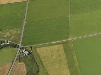 Oblique aerial view centered on the cropmarks of a barrow at Hall of Ireland with the farmstead and mill of Ireland adjacent, taken from the SE.