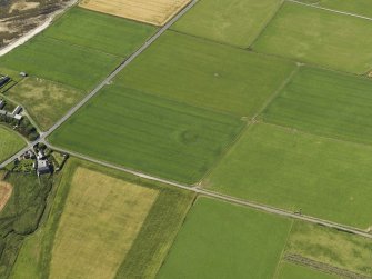 Oblique aerial view centered on the cropmarks of a barrow at Hall of Ireland with the farmstead and mill of Ireland adjacent, taken from the S.