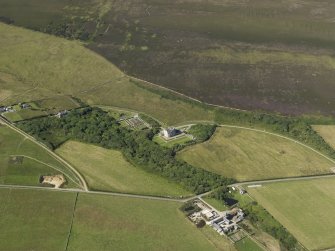 Oblique aerial view centered on the chambered cairn at Taversoe Tuck with Trumland House adjacent, taken from the SSE.