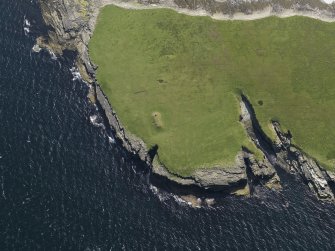 Oblique aerial view centred on the chambered cairn (south) on Holm of Papa Westray, taken from the NNE.