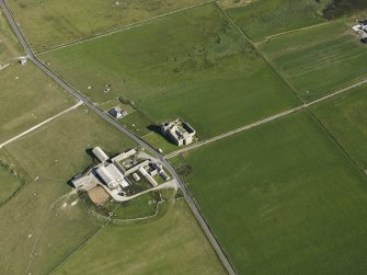 Oblique aerial view centred on the ruins of Noltland Castle with Noltland farmsteading adjacent, taken from the NW.
