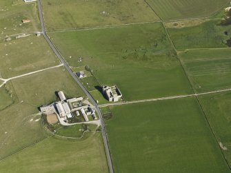 Oblique aerial view centred on the ruins of Noltland Castle with Noltland farmsteading adjacent, taken fromt he WNW.