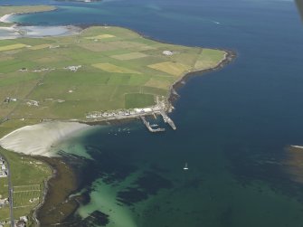 General oblique aerial view of the NE of Westray centred on Pierowall harbour, taken from the SW.