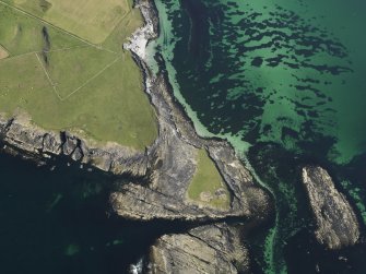 Oblique aerial view centred on the Knowe of Skea broch and the excavation of the cemetery, taken from the SSW.
