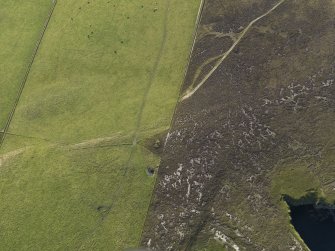 Oblique aerial view centred on the remains of the Castle Bloody chambered cairn, taken from the SE.