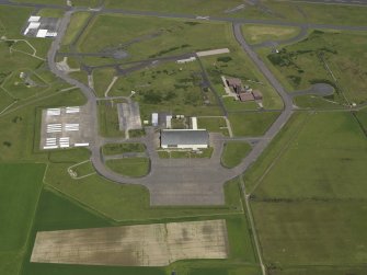 General oblique aerial view centred on the 'Gaydon' aircraft hangar with the USN base adjacent, taken from the S.