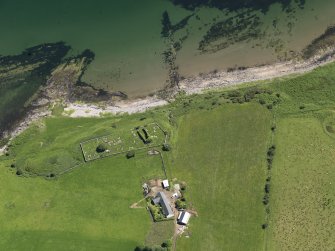 Oblique aerial view centred on the remains of the church with the farmstead adjacent, taken from the W.