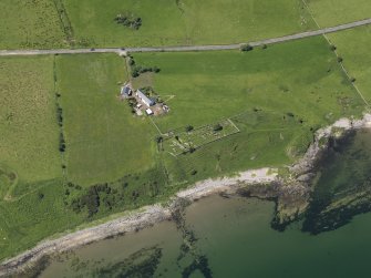 Oblique aerial view centred on the remains of the church with the farmstead adjacent, taken from the E.