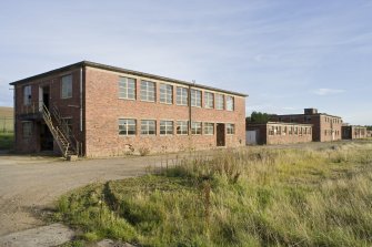 General view from NW of the receiving electrical/despatch stores, central and clothing stores with the pest control hut.
