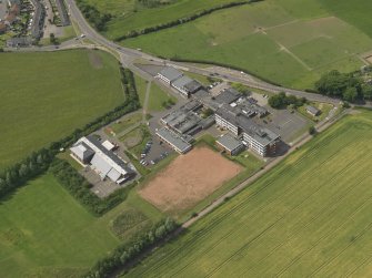 Oblique aerial view centred on the school/community centre with the primary school adjacent, taken from the NE.