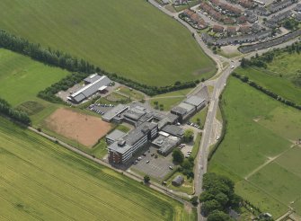 Oblique aerial view centred on the school/community centre with the primary school adjacent, taken from the NW.