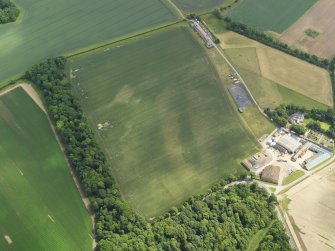 Oblique aerial view of the cropmarks of the settlement and barrows, with the Luffness Mains cottages adjacent, taken from the W.