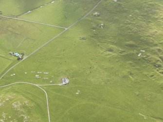 Oblique aerial view centred on the remains of the huts, taken from the NW.