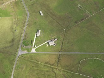 Oblique aerial view centred on the remains of the radar station buildings with the remains of the croft adajacent, taken from the SW.