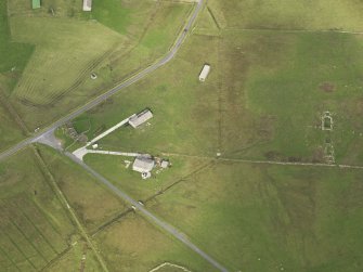 Oblique aerial view centred on the remains of the radar station buildings with the remains of the croft adajacent, taken from the SE.