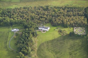 Oblique aerial view centred on the country house with the garage adjacent, taken from the NW.