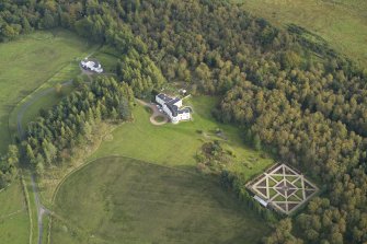 Oblique aerial view centred on the country house with the garage adjacent, taken from the WNW.