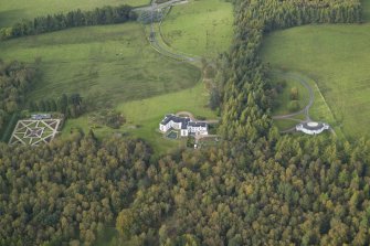 Oblique aerial view centred on the country house with the garage adjacent, taken from the SE.