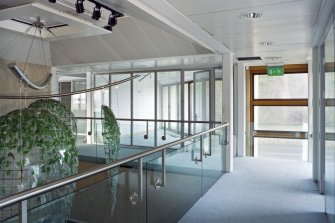 Interior. View of 1st floor gallery around reception area, including corner office and sculptural light fitting.