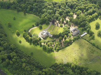 Oblique aerial view of Caprington Castle and stables, taken from the NNW.